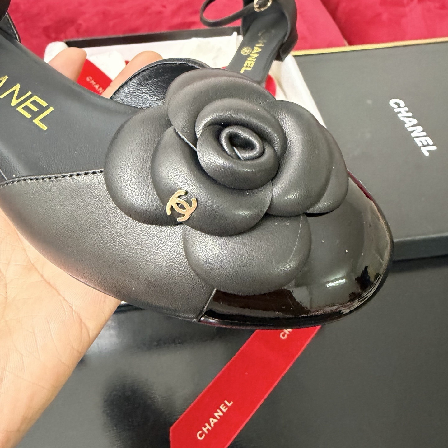 Pair of black Chanel ankle strap flats featuring a large camellia flower and patent leather toe cap in a luxury gift box. - Hình 6