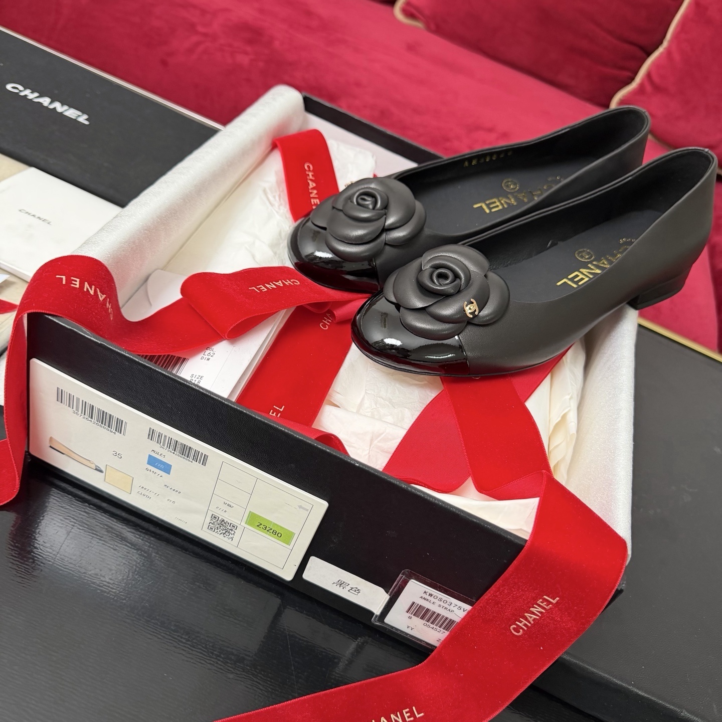 Luxury Chanel black leather ballet flats with camellia flower detail and patent toe cap in original packaging with red ribbon. - Hình 2