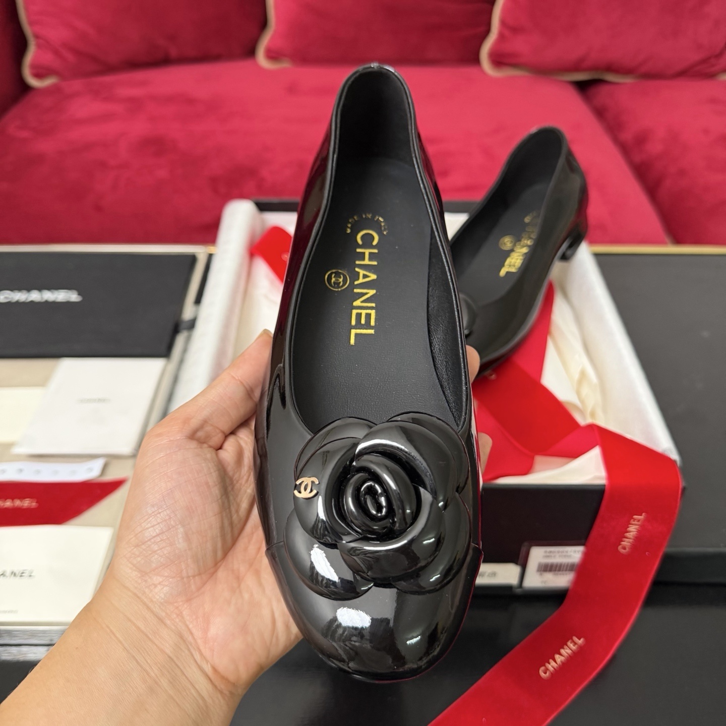 Luxury Chanel black patent leather ballet flats featuring a camellia flower with a gold CC logo on the toe. - Hình 3