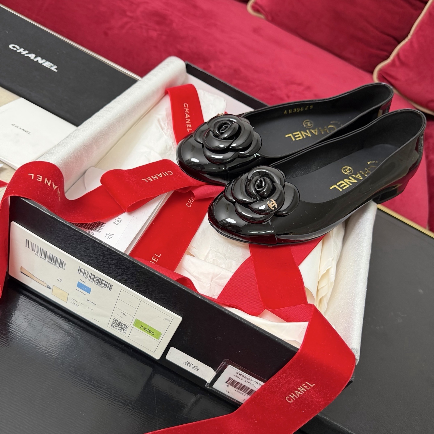 Luxury Chanel black patent leather ballet flats featuring a camellia flower with a gold CC logo on the toe. - Hình 2