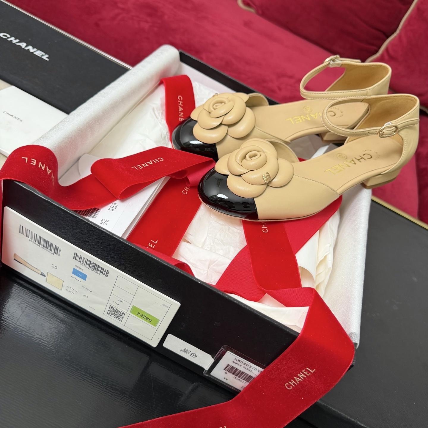 Luxury beige and black two-tone ankle strap shoes with a large camellia flower detail on the toe. - Hình 2