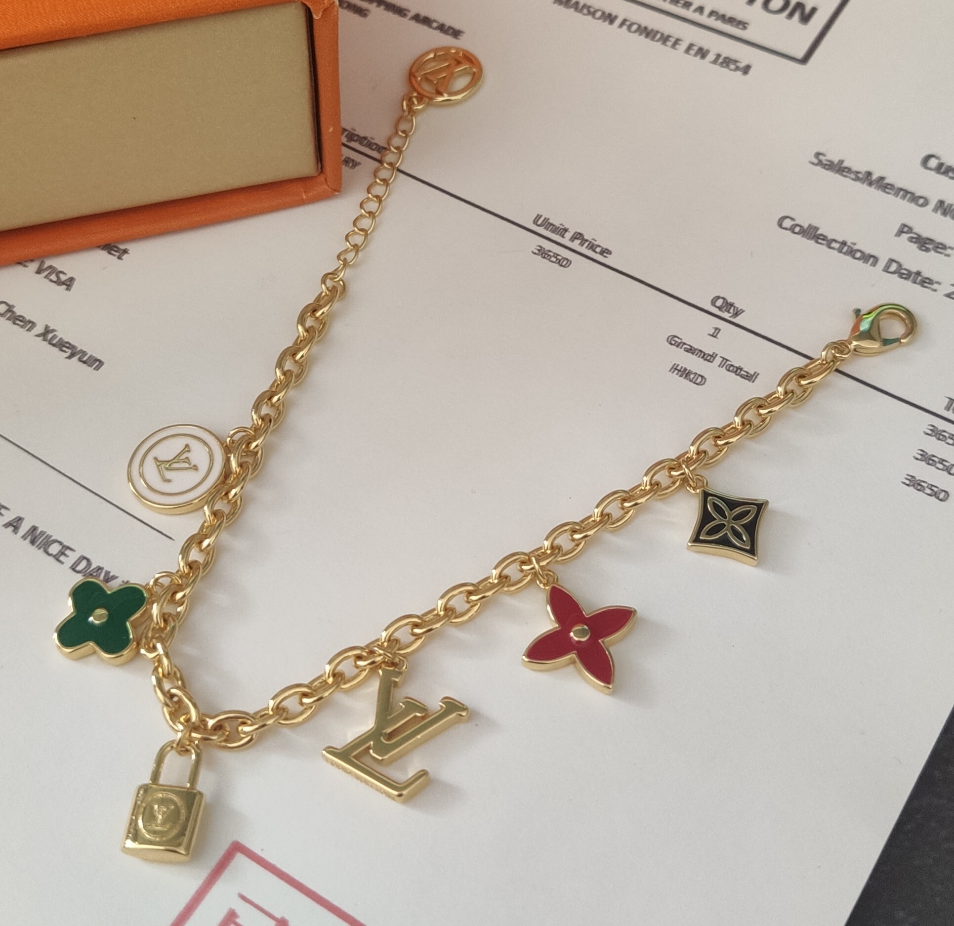 Gold plated charm bracelet with floral and LV logo charms
