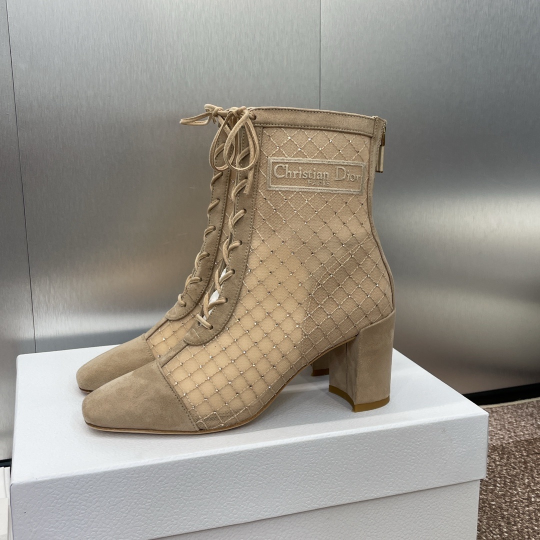 A pair of Christian Dior D-Fight beige mesh lace-up ankle boots with crystal embellishments and block heels on a white box.