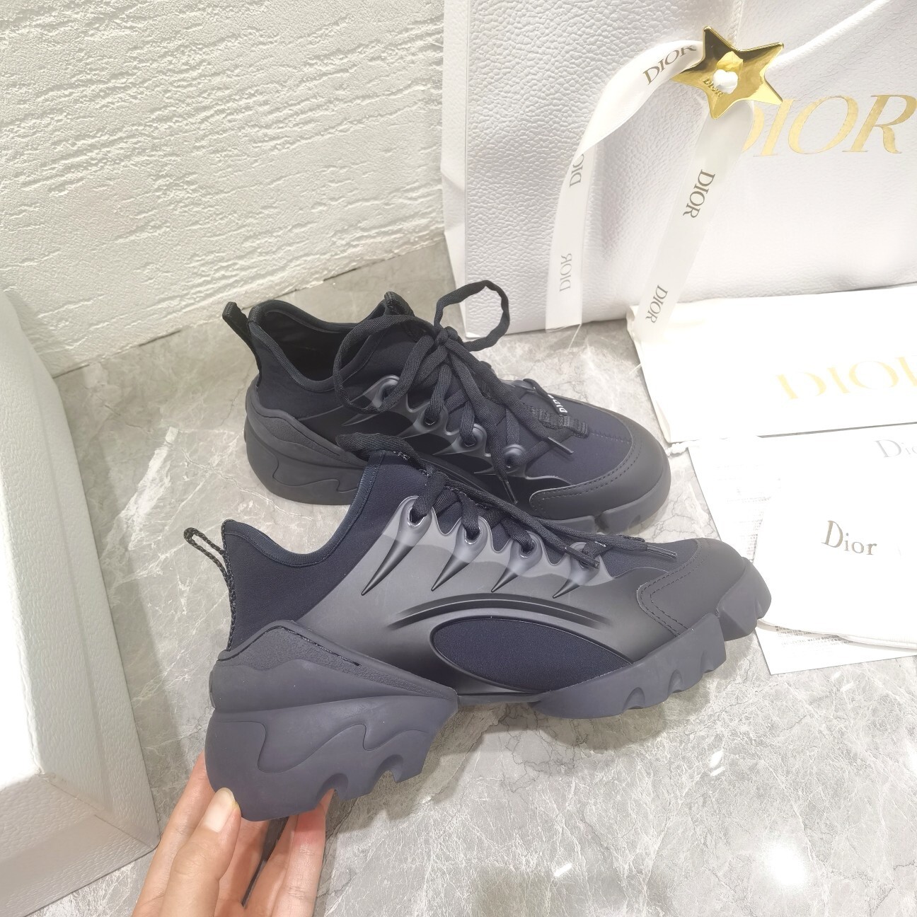 A pair of luxury Dior Vibe sneakers in black technical fabric and mesh with a chunky sculpted sole.