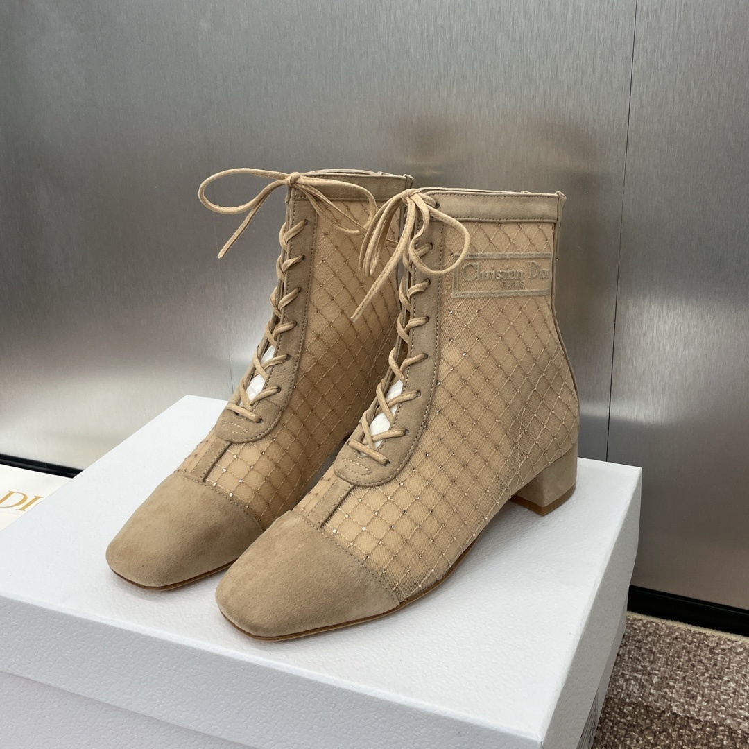 A pair of Dior D-Fight beige mesh lace-up ankle boots with crystal embellishments and suede toe caps, displayed on a white Dior shoebox.