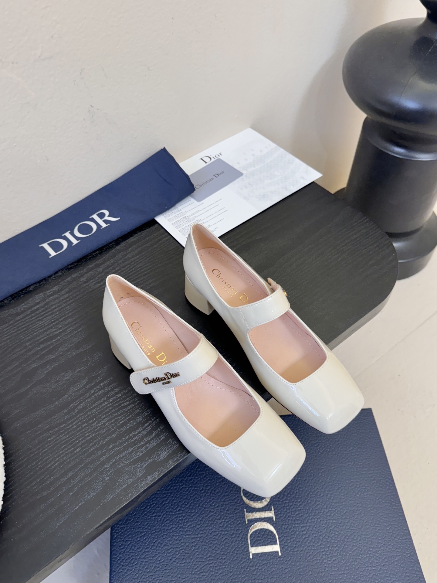 Elegant Dior cream patent leather Mary Jane pumps with a square toe and block heel featuring the Christian Dior logo on the strap.