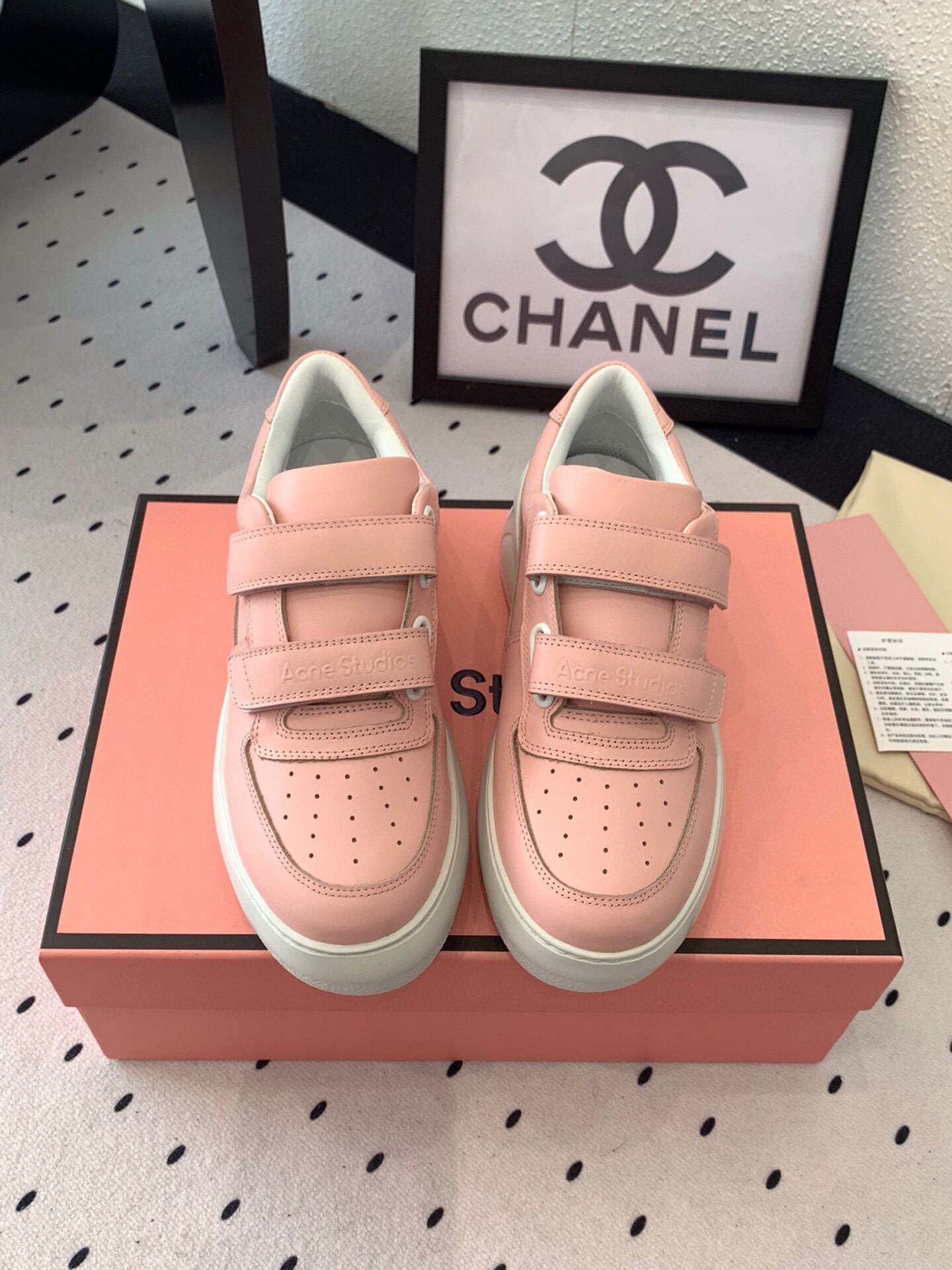 Acne Studios pink leather platform sneakers with velcro straps and chunky white soles on a pink box