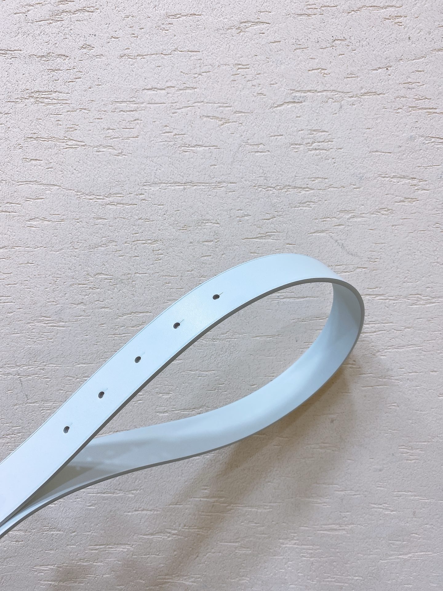 White leather belt with gold metal buckle engraved with Miu Miu